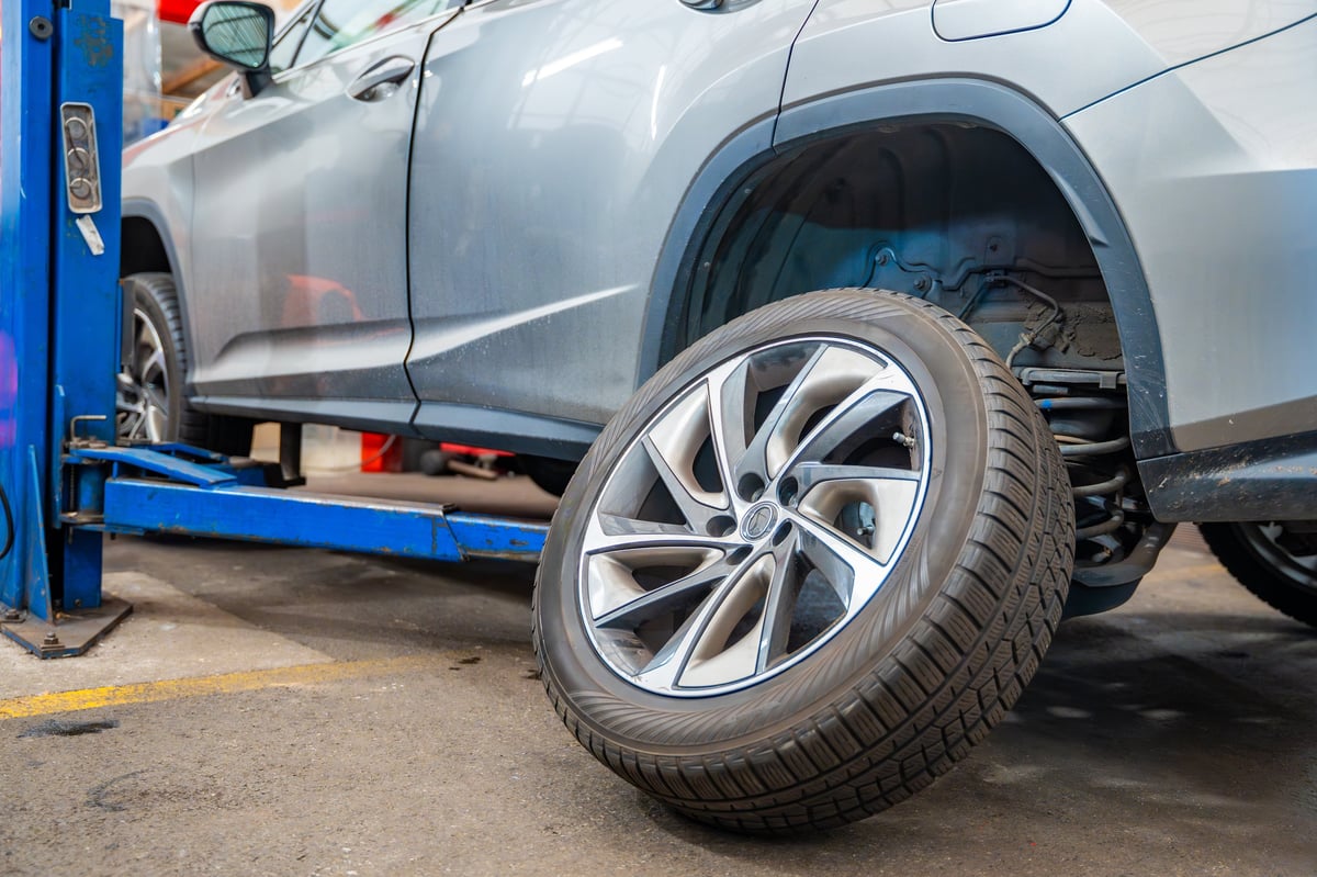 A prepared wheel resting beside a vehicle before fitting at the Yeppoon workshop